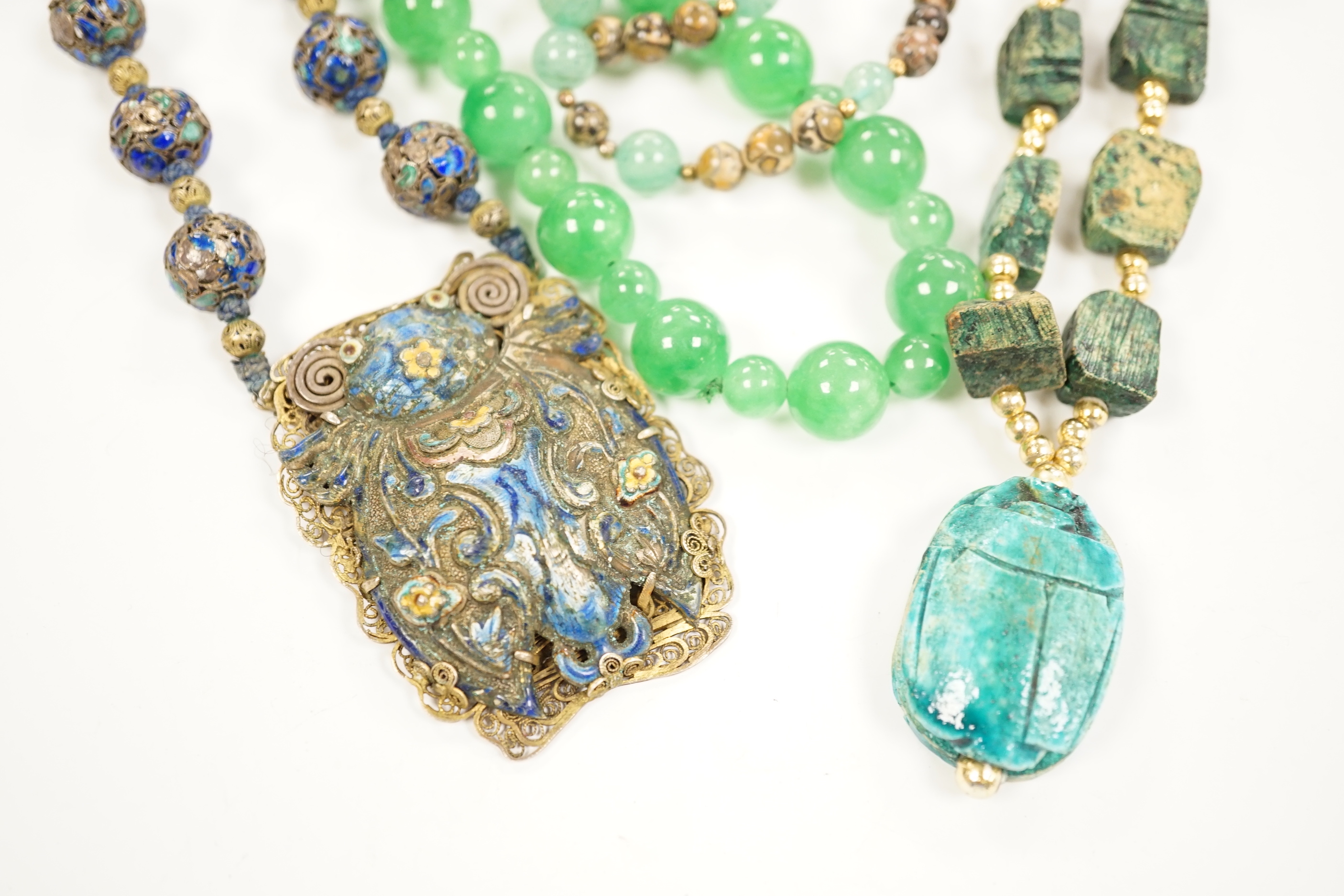 Three assorted Chinese bead necklaces including filigree gilt white metal and enamel pendant necklace, overall 68cm and a jade bracelet.